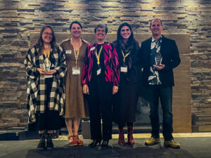 5 people standing, 4 women, 1 man